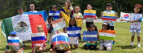 kids outside holdings posters they made to look like the flag of their country