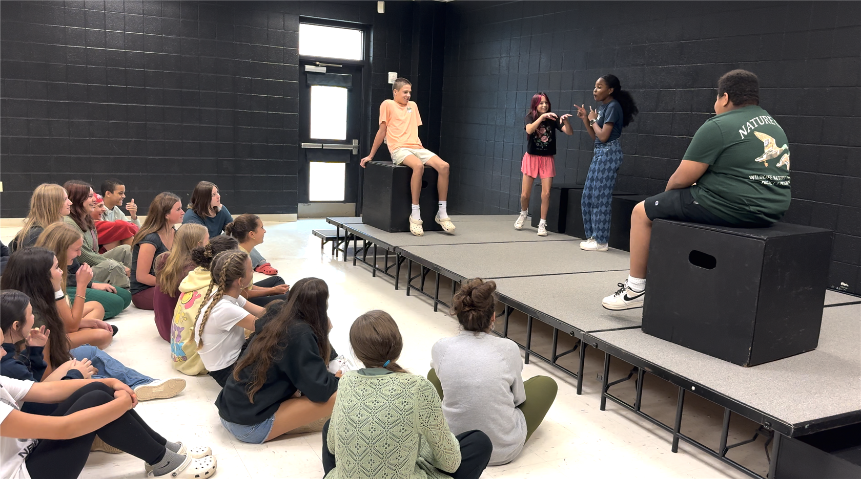  Middle school theater arts students improvising on stage