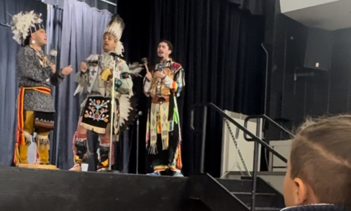  Student watches Native American performers on stage.