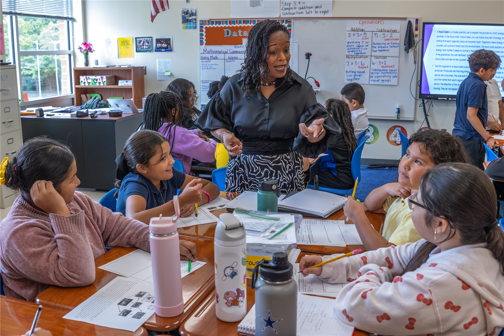 Principal Angela Grant talking with students in a classroom.