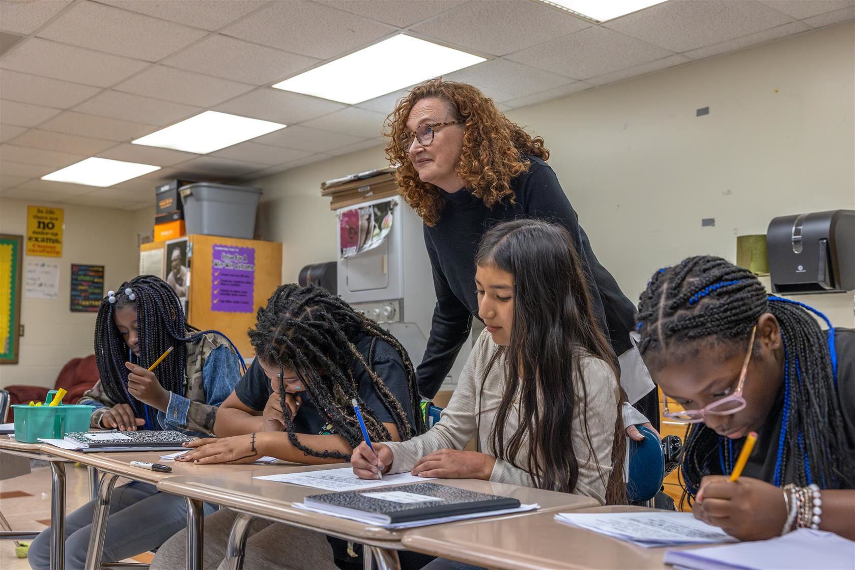 Coulwood STEM principal stands behind a row of students in a classroom