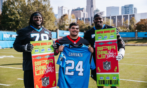 Olympic High School senior Lucas Carranza (center) stands between two Carolina Panthers players