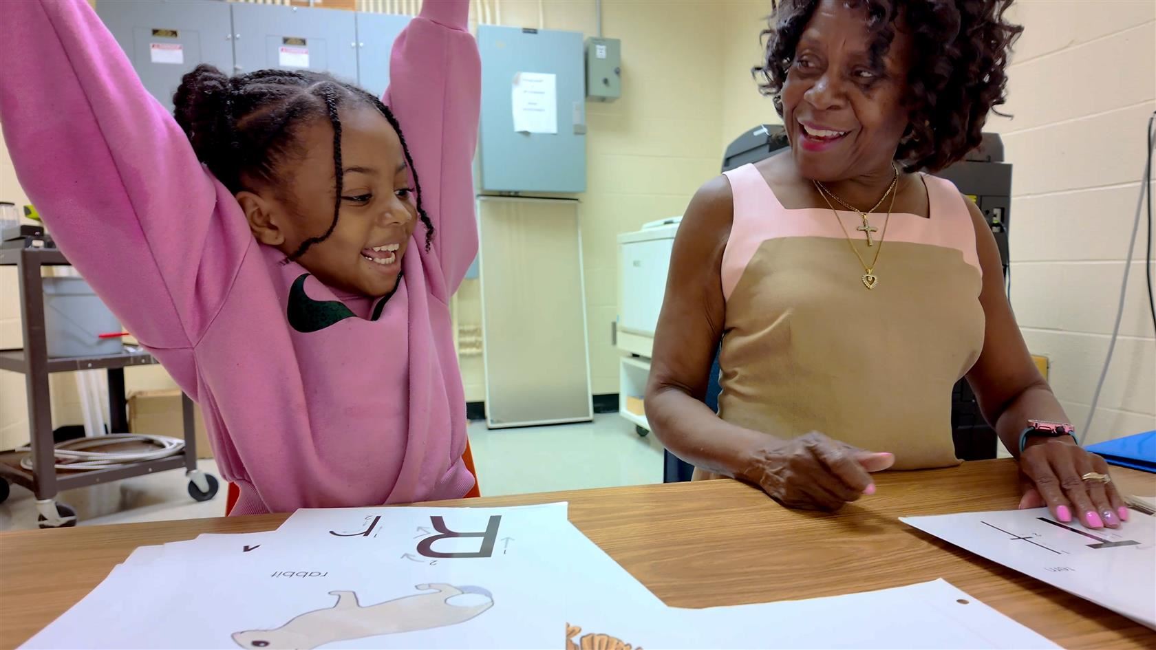  School volunteer, Metta Hughes, works with pre-K students on letter recognition and counting