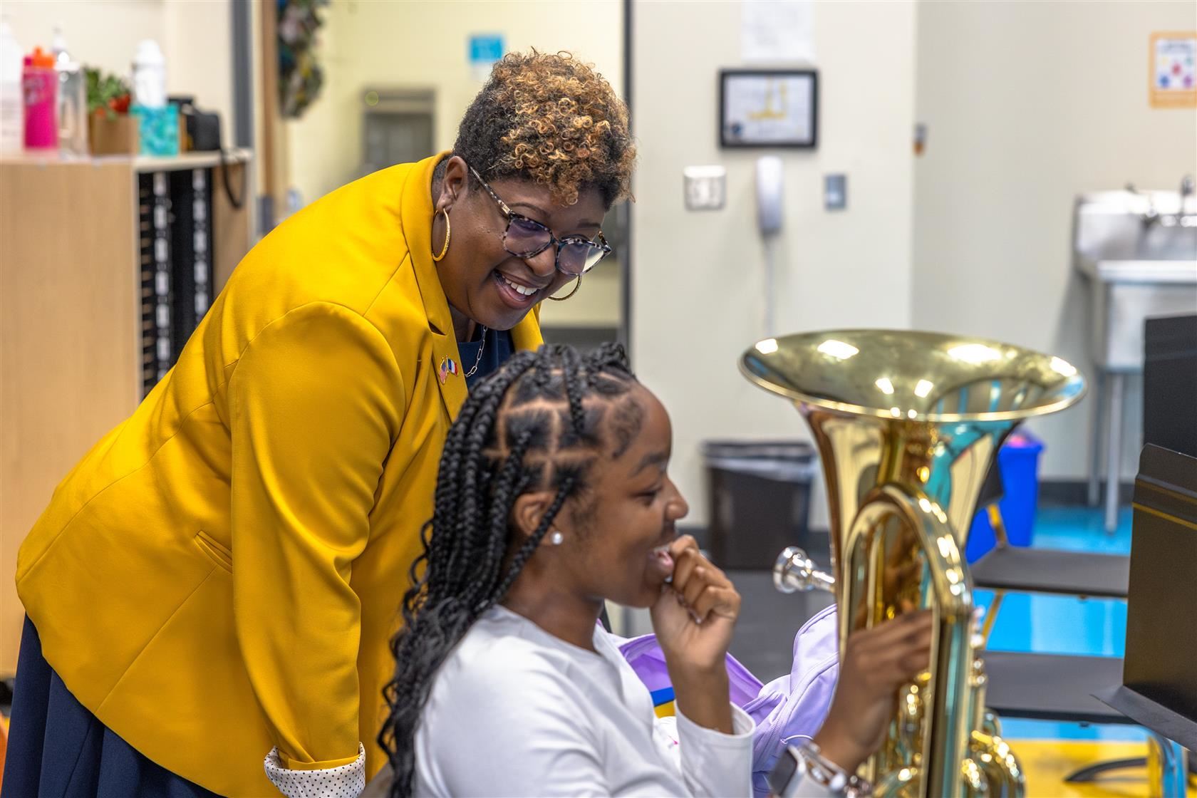 NAWL Principal Lydia Fergison stand above student holding a euphonium