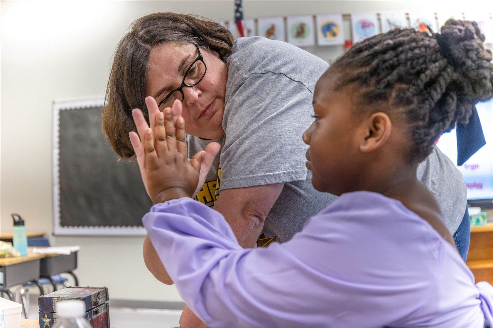 Principal Range giving a student a high five.