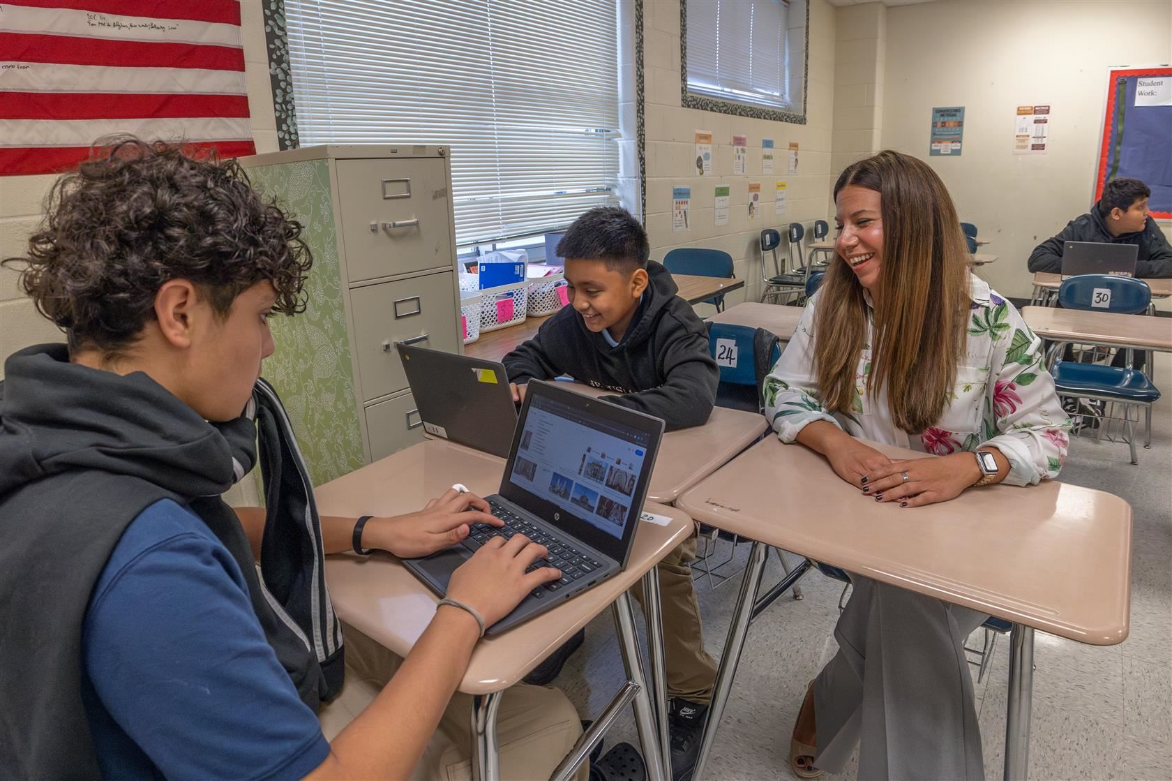 MLK Principal Jessica Savage sits at a desk with two students