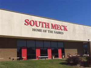 Front of South Mecklenburg High School Campus with building text that reads: South Meck Home of the Sabers